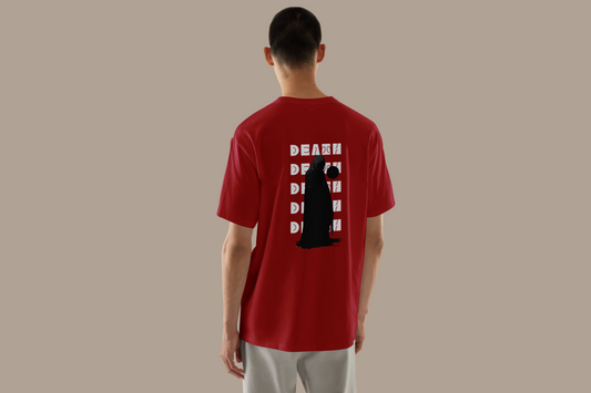 Back view of a person wearing a Red oversized T-shirt featuring a bold graphic design. The design includes a central grayscale illustration of a cloaked figure with a red 'DEATH' label over their eyes, surrounded by the word 'DEATH' repeatedly arranged in a wavy, distorted pattern.